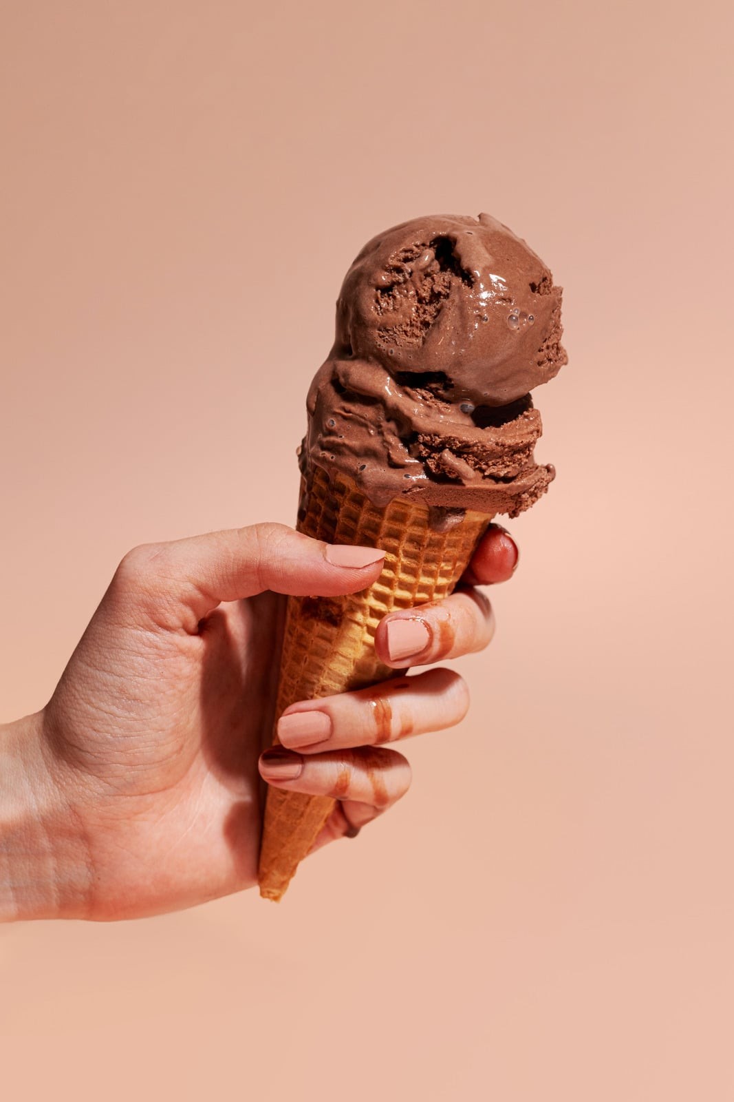 Hand holding a chocolate ice cream cone from Ice Klub